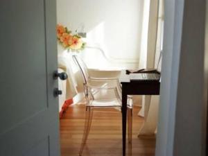 科內利亞諾的住宿－Locanda Mezzosale，客房设有一张桌子、一把椅子和一张带花卉的桌子。