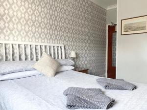 a bedroom with a white bed with a patterned wall at Friars Rest Guest House in York