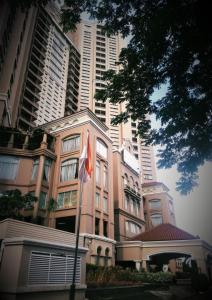 wysoki budynek z flagą przed nim w obiekcie Ancol Marina Residence w Dżakarcie