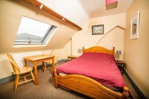 a bedroom with a bed and a table and a window at Llangollen Hostel Self-catering in Llangollen