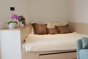 uma cama com almofadas castanhas e uma cadeira azul em Crystal Studio em Kutná Hora