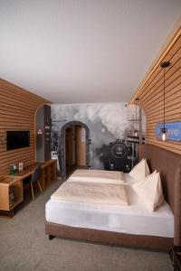 1 dormitorio con 1 cama y un mural de tren en Gasthof Berghof, en Semmering