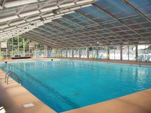 a large swimming pool with blue water in a building at Eagle Mountain River Retreat in Ellijay