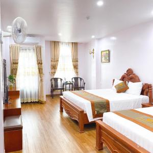 Habitación de hotel con 2 camas y mesa en TRƯỜNG GIANG HOTEL Móng Cái en Móng Cái