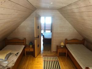 Cette chambre mansardée comprend 2 lits et une fenêtre. dans l'établissement Sävekulla 207 "Brygghuset", à Älvsered