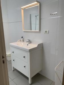 een witte badkamer met een wastafel en een spiegel bij Bandama 15 2 Bedroom Ground Floor in Los Pocillos