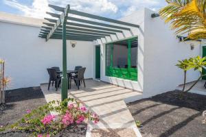 a patio with a green door and a table and chairs at Bandama 15 2 Bedroom Ground Floor in Los Pocillos