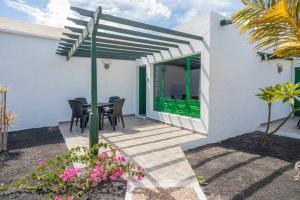 un patio con puerta verde, mesa y sillas en Bandama 15 2 Bedroom Ground Floor, en Los Pocillos