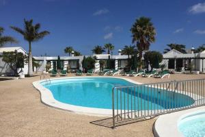 a large swimming pool in a resort with palm trees at Bandama 15 2 Bedroom Ground Floor in Los Pocillos
