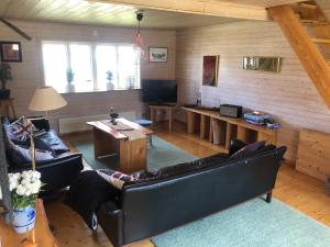 een woonkamer met leren banken en een televisie bij Sävekulla 207 "Brygghuset" in Älvsered