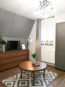 a living room with a coffee table and a tv at ✰Mansarda na Białoskórniczej✰5 minut od Rynku in Wrocław