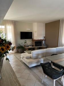 a living room with a couch and a flat screen tv at Villa Mancosta in Marinella di Selinunte