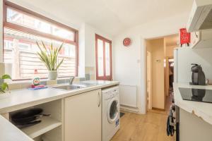 a kitchen with a washer and dryer on a counter at Victorian Home, 3BR, Airport, M1, 6 beds, sleeps 12 in Luton