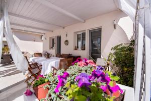 eine Terrasse mit Blumen, einem Tisch und Stühlen in der Unterkunft Holiday Fontane Bianche Gabriella in Fontane Bianche