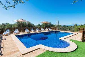 a swimming pool with chairs and umbrellas at Finca Can Valero in La Aranjasa