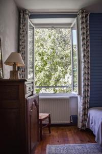 a bedroom with a window and a bed and a chair at Utah Beach Chambre hote in Sainte-Marie-du-Mont
