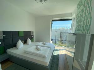 a bedroom with a bed and a large window at Luxury Garden House II In The Center in Balatonfüred