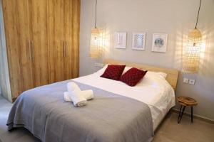 a bedroom with a large bed with red pillows at Havana 2 Luxury sea and pool in Gázion +17 photos