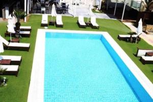 a swimming pool with chaise lounge chairs and a pool at Havana 2 Luxury sea and pool in Gázion