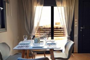 a dining room table with chairs and a large window at Havana 2 Luxury sea and pool in Gázion
