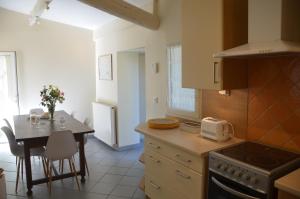 a kitchen with a table and a dining room at Le Mas Sivan séjour arlésien 2 à 6 personnes wifi climatisation parking in Arles