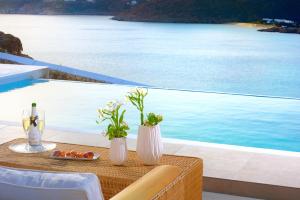 una mesa con dos jarrones blancos encima de una piscina en Luxurious Villa Ostria en Elia Beach