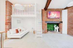 a living room with a white couch and a fireplace at Spa des Carmes in Toulouse