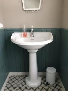 a white sink in a bathroom with green walls at Overvoll Farm in Stranda