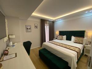 una camera d'albergo con un grande letto e una scrivania di Brais Boutique Hotel a Durrës