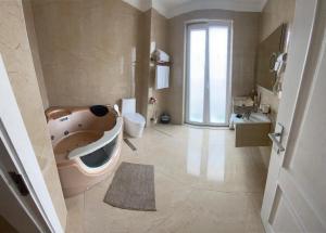a bathroom with a tub and a toilet and a sink at Brais Boutique Hotel in Durrës