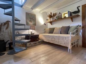 a bedroom with a bed and a spiral staircase at La Finestra sul Fiume in Valeggio sul Mincio