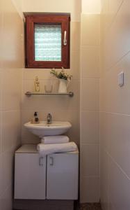 a bathroom with a sink and a window and towels at Smokvica - Feigenbaum in Kornić
