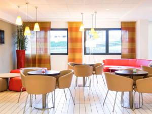 - un restaurant avec des tables et des chaises dans une salle dans l'établissement Hotel Ibis Milano Malpensa, à Cardano al Campo