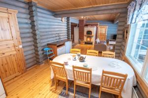 Villa Mertala في Pääjärvi: غرفة طعام ومطبخ في كابينة خشب مع طاولة وكراسي