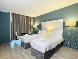 a hotel room with two beds and a window at Axiom Park Hotel in London