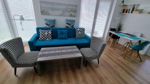 メヘリンキにあるApartament Vespaのリビングルーム(青いソファ、椅子付)