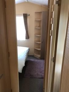A bed or beds in a room at Pet friendly riverside static caravan