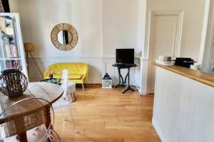 a living room with a yellow couch and a table at Beau 2 pièces en centre ville et à 200m de la mer in Cabourg