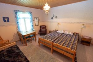 Un dormitorio con una cama y un escritorio y una ventana. en Villa Rentola, en Pääjärvi