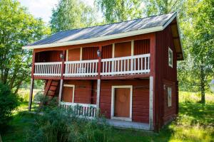 a red log cabin with a gambrel roof at Villa Rentola in Pääjärvi +26 photos