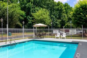 a swimming pool with chairs and an umbrella at Quality Inn & Suites Decatur - Atlanta East in Decatur