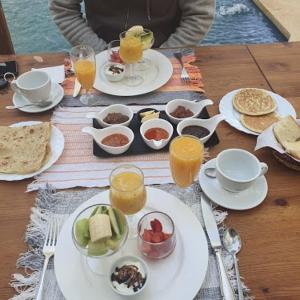 una mesa con platos de comida y vasos de zumo de naranja en Dar Blues en Boumalne