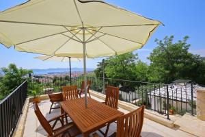 a wooden table and chairs with an umbrella on a balcony at Eler Home in Zadar