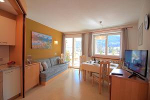a kitchen and living room with a couch and a table at Appartement Hotel Erlhof Deluxe in Lutago