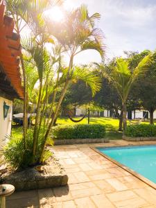 een resort met een zwembad en palmbomen bij Peixe Crew Manguinhos in Búzios