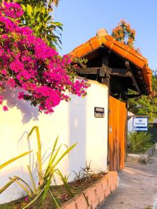 a small building with pink flowers on it at Peixe Crew Manguinhos in Búzios