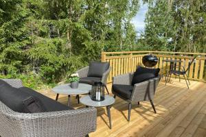 a deck with couches and chairs and a table at Naturnära boende i vackra Järvsö - H in Järvsö
