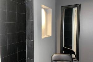 a bathroom with a shower and a chair and a mirror at Naturnära boende i vackra Järvsö - H in Järvsö