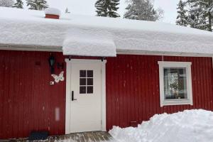 a red house with a white door and a butterfly on it at Naturnära boende i vackra Järvsö - H in Järvsö