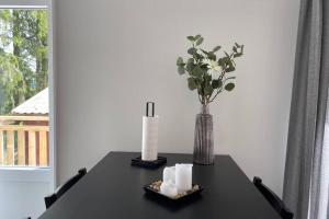 a black table with a vase and candles on it at Naturnära boende i vackra Järvsö - H in Järvsö
